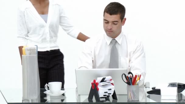 Affärskvinna som talar till en affärsman som arbetar i hans kontor — Stockvideo