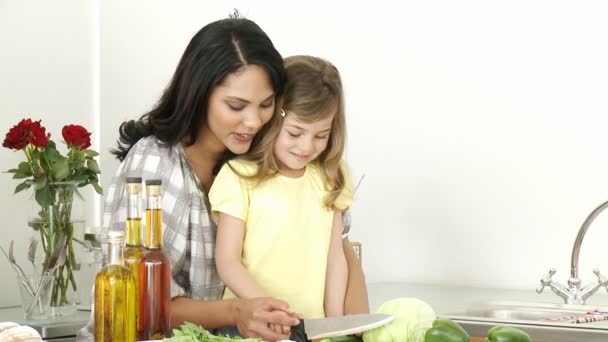 Mother and little girl cutting vegetables — Stock Video