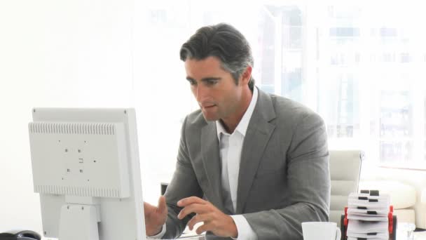 Hombre de negocios exitoso trabajando en una computadora — Vídeos de Stock