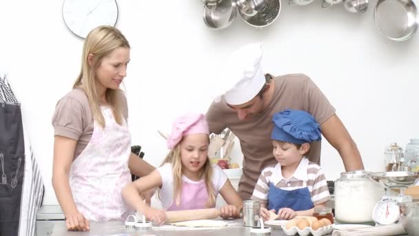 Barnen baka kakor med sina föräldrar i köket. — Stockvideo