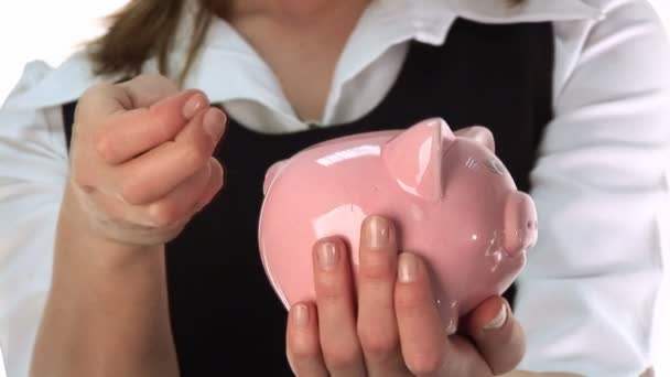 Vrouw geld te besparen in een piggy bank — Stockvideo