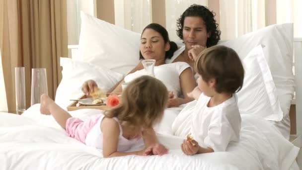 Padres felices y niños desayunando en el dormitorio — Vídeos de Stock