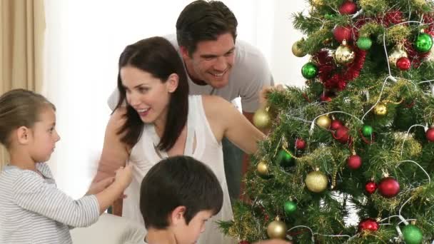 Familia decorando un árbol de Navidad en casa — Vídeos de Stock