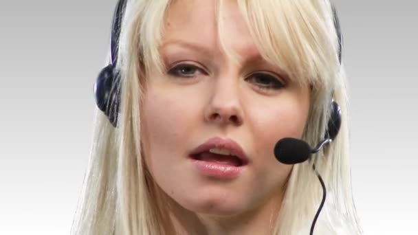 Schöne blonde Frau spricht auf einem Headset — Stockvideo