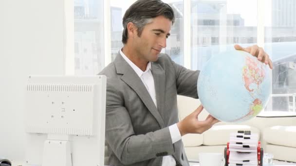 Homem de negócios elegante segurando um globo terrestre — Vídeo de Stock