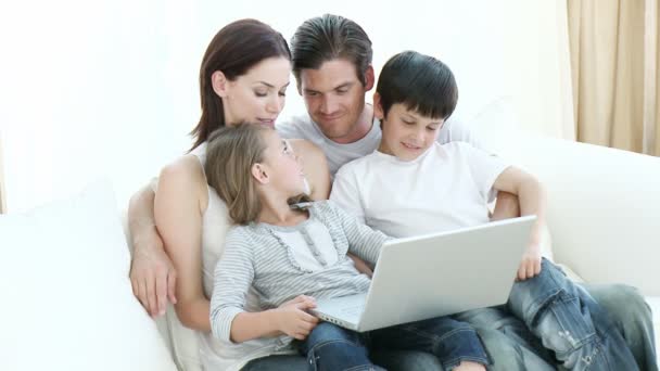 Familia joven usando un portátil en casa — Vídeos de Stock