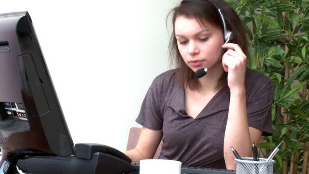 Концентрированная женщина с гарнитурой на работе за компьютером — стоковое видео