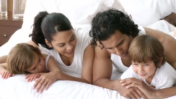 Familia feliz divirtiéndose en la cama — Vídeo de stock