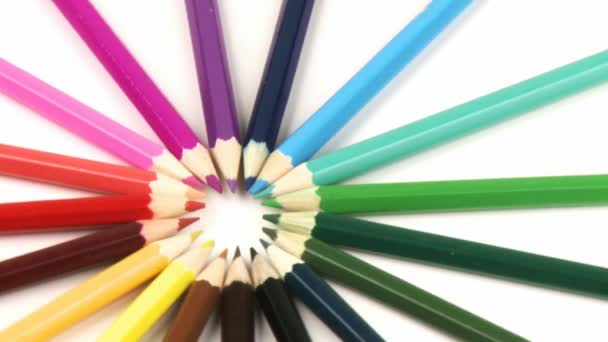 Lápis de cor em um círculo girando como uma roda contra branco — Vídeo de Stock