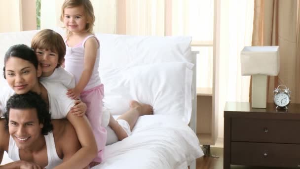 Genitori felici e bambini che si divertono a letto — Video Stock