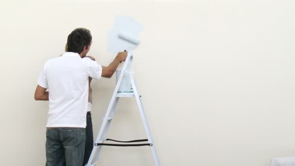 Pareja pintando una habitación en casa nueva — Vídeo de stock