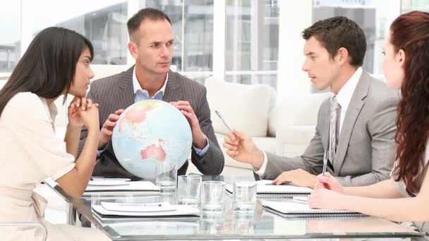 Manager holding a terrestrial globe in a meeting — Stock Video
