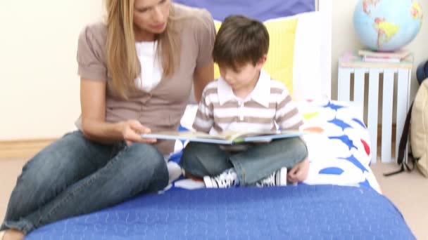 Mutter liest mit ihrem Sohn ein Buch — Stockvideo