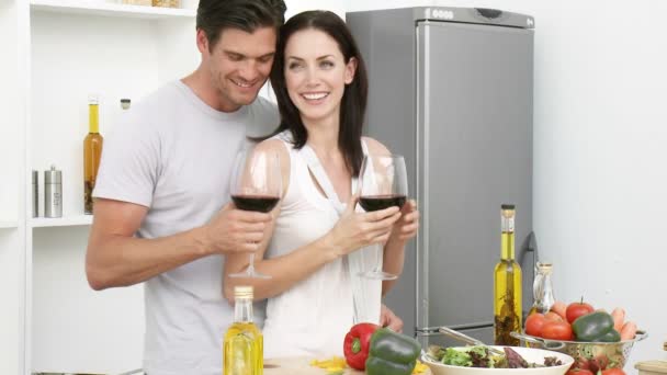 Пара пьет вино и ест салат на кухне — стоковое видео