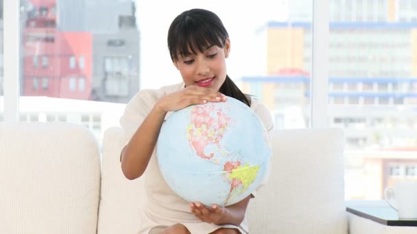 Joven empresaria mirando un globo terrestre — Vídeo de stock