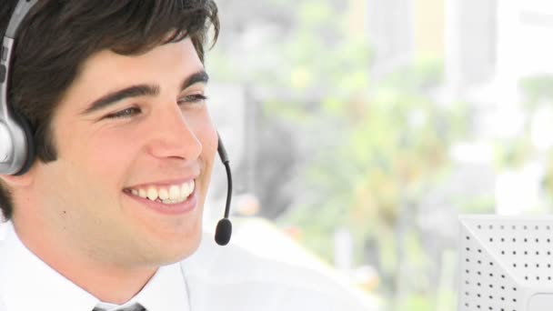 Young attractive businessman talking on a headset — Stock Video