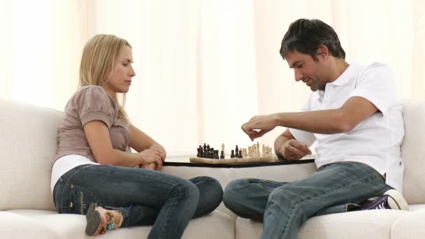 Couple jouant aux échecs sur canapé dans le salon — Video