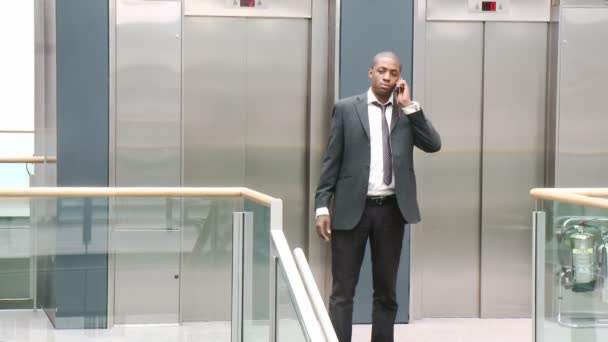 Αφρο-αμερικανικό επιχειρηματίας στο τηλέφωνο σε ένα κτίριο — Αρχείο Βίντεο
