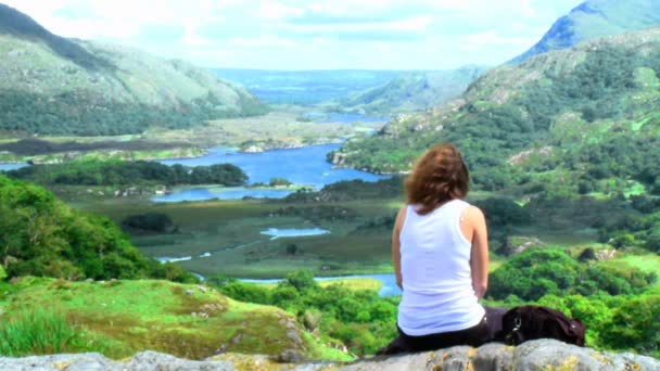 Jovem mulher sentada no topo de uma montanha — Vídeo de Stock