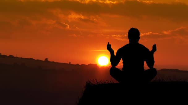 Мужчина медитирует на закате — стоковое видео
