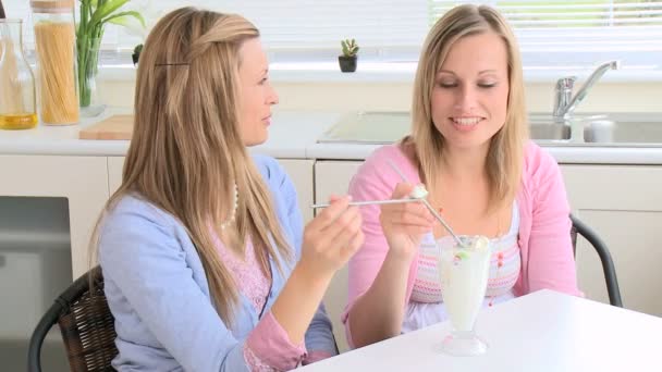 Mulheres radiantes comendo sorvete sentado em uma mesa — Vídeo de Stock