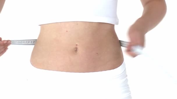 Jovem bela mulher medindo sua cintura com uma fita métrica — Vídeo de Stock