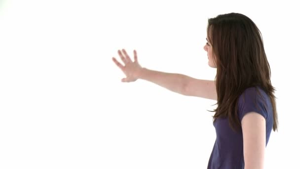 女性はカメラに白い壁を示す — ストック動画