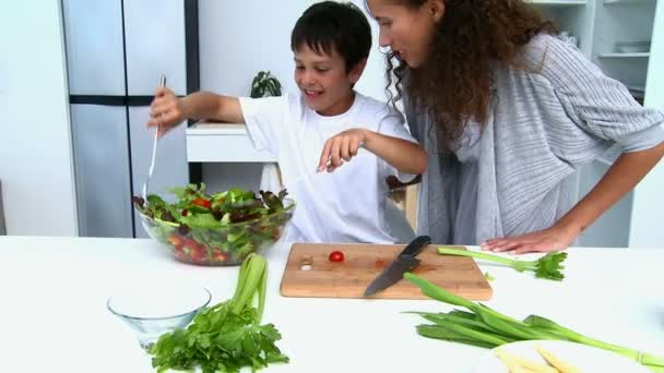 Niño cocinando una ensalada con su madre — Vídeos de Stock