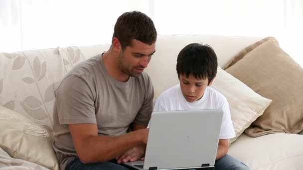 Батько і син дивляться на ноутбук — стокове відео