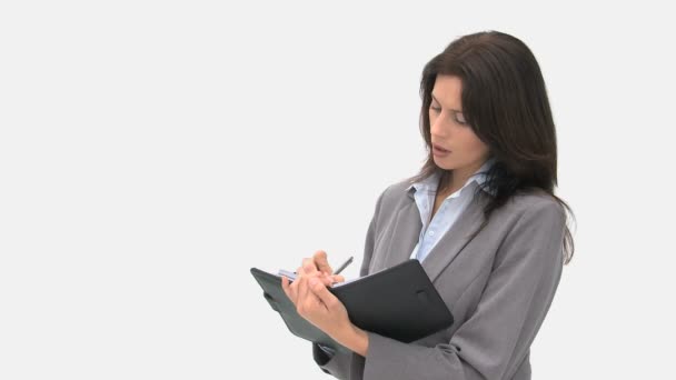Business woman writing on her agenda — стоковое видео