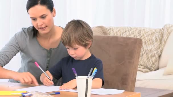 Adorable madre ayudando a su hijo a dibujar — Vídeo de stock