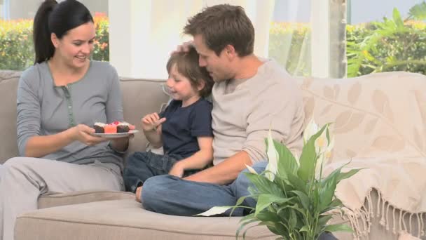 Жінка дає торти своєму синові і чоловікові — стокове відео