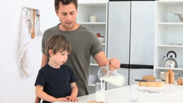 Отец, подающий стакан молока своему сыну — стоковое видео