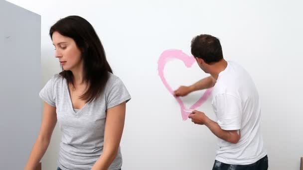 Чоловік малює серце на стіні — стокове відео