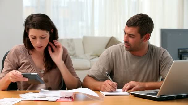 Pareja calculando sus cuentas juntas en la sala de estar — Vídeos de Stock