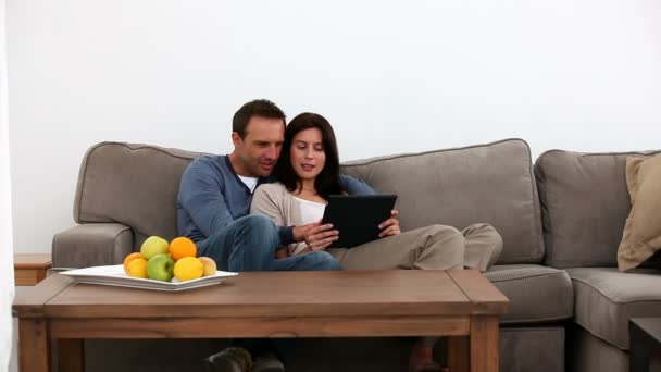 Счастливая пара смотрит на планшет — стоковое видео