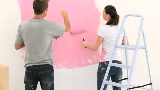 Bonita pareja pintando la pared juntos — Vídeos de Stock