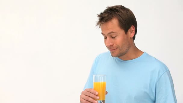 Homem bebendo um copo de suco de laranja — Vídeo de Stock