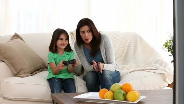Alegre mamá animando a su hija a jugar videojuegos — Vídeo de stock