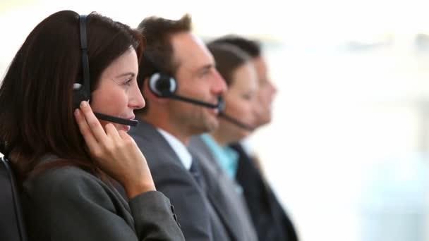 Glimlachende klanten service agenten werken in een callcenter — Stockvideo