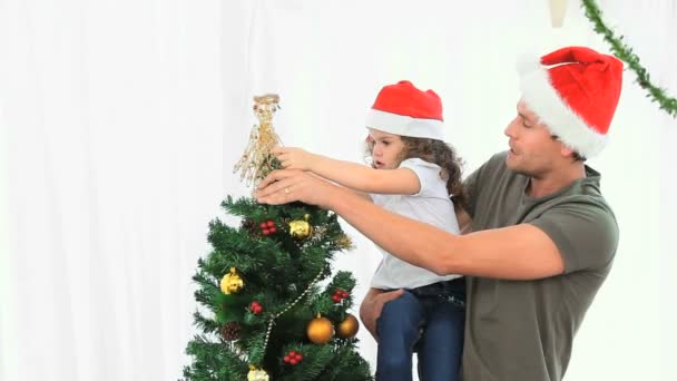 Homem ajudando sua filha a decorar a árvore de Natal — Vídeo de Stock