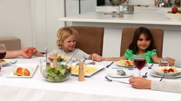 Familie bidden samen tijdens de lunch — Stockvideo