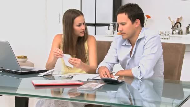 Pareja joven hablando de sus deudas en una mesa — Vídeos de Stock