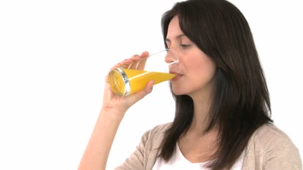 Mujer sonriente bebiendo jugo de naranja — Vídeos de Stock