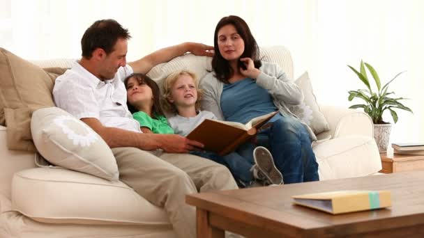 Linda familia leyendo un libro — Vídeo de stock