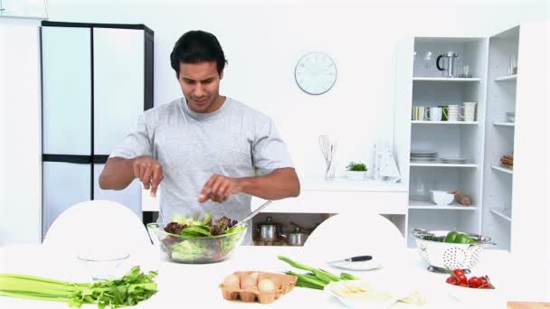 Man eating while he is cooking — Stock Video