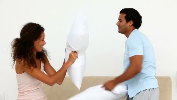 Hombre y mujer teniendo una pelea de almohadas — Vídeo de stock