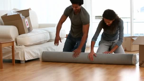 Paar rollt Teppich aus — Stockvideo