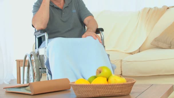Człowiek na wózku inwalidzkim, śmiejąc się przez telefon — Wideo stockowe