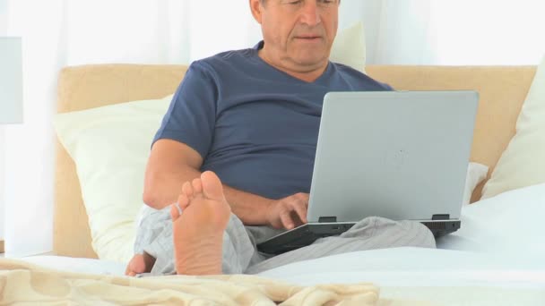 Зрелый человек фокусируется на ноутбуке — стоковое видео